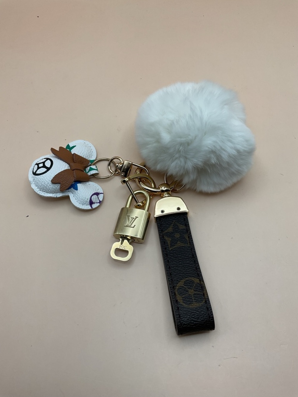 Monogram Leather Strap Keychain with Louis Vuitton Gold Lock and White Pom Pom